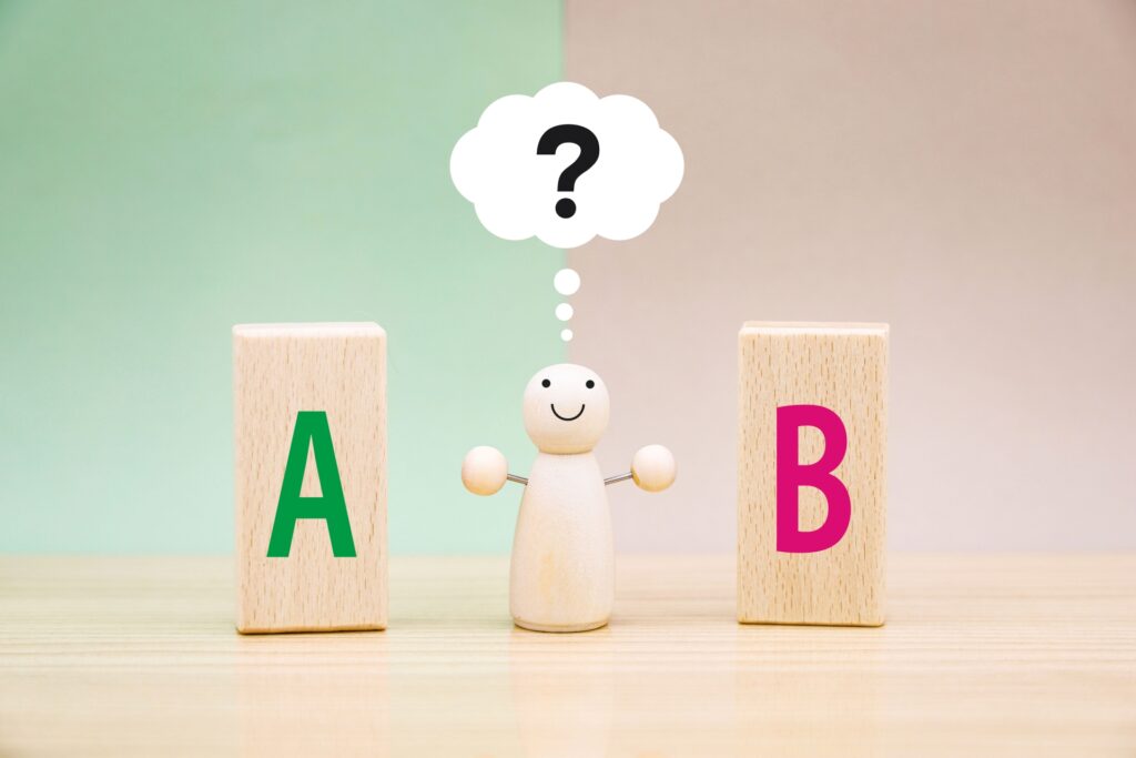 AかBの2択で迷っている人形の画像