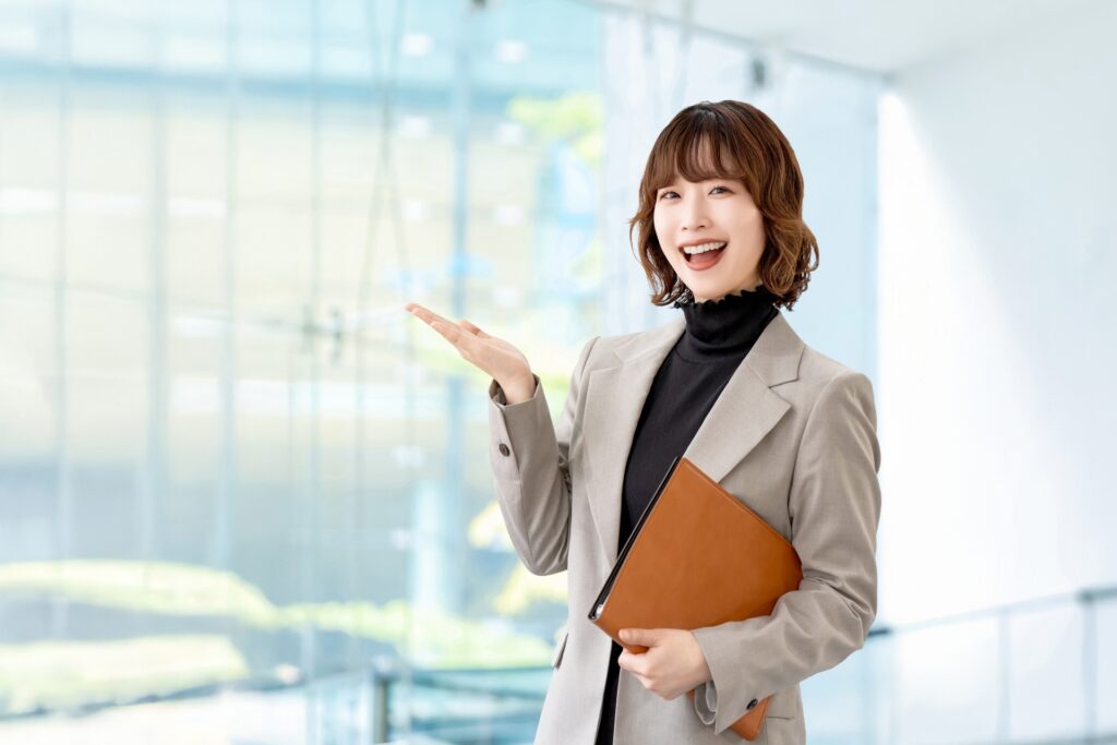 手で案内をする女性・ビジネスウーマンの画像