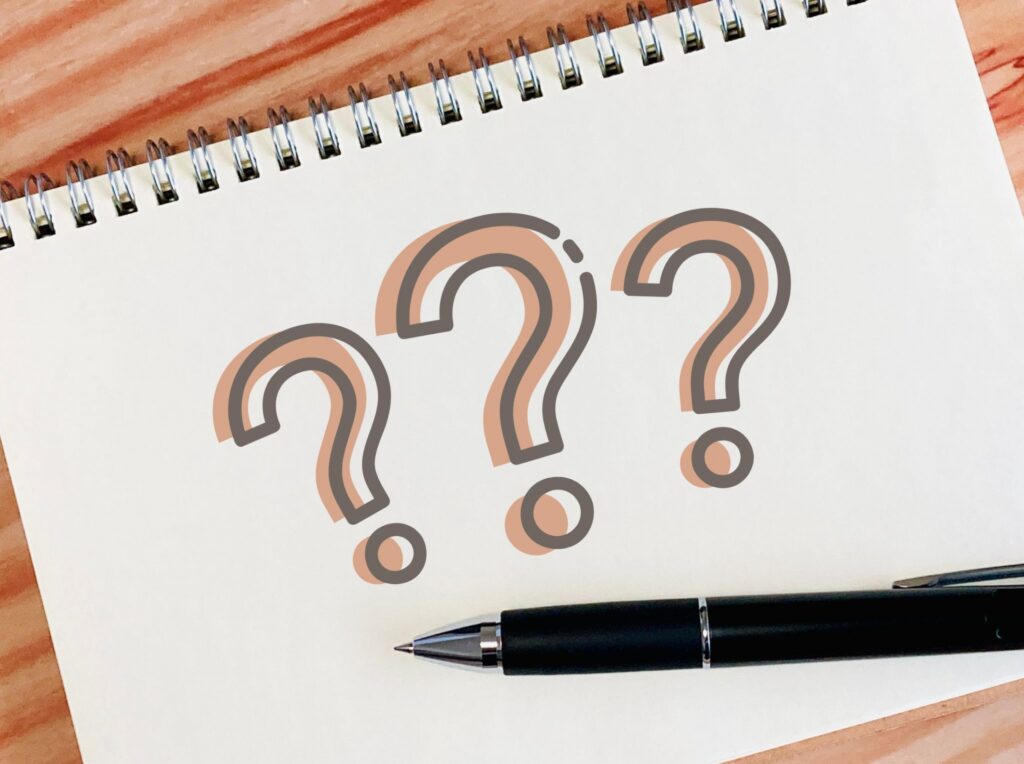 茶色いクエスチョンマーク3つが画用紙に書いてある画像