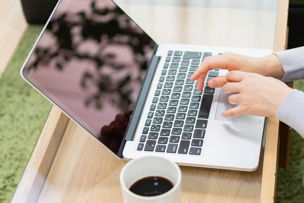 ノートパソコンを使う若い女性の画像