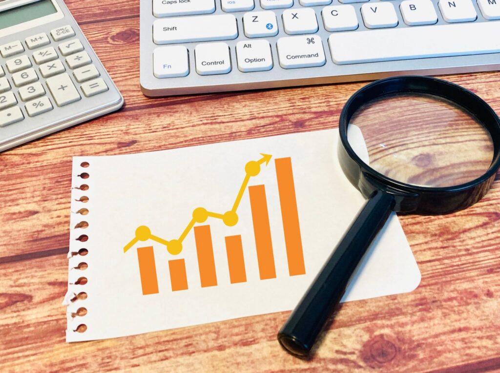 グラフと虫眼鏡とパソコンの画像