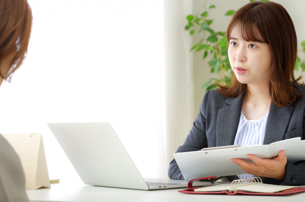 顧客と話し合いをする女性の画像