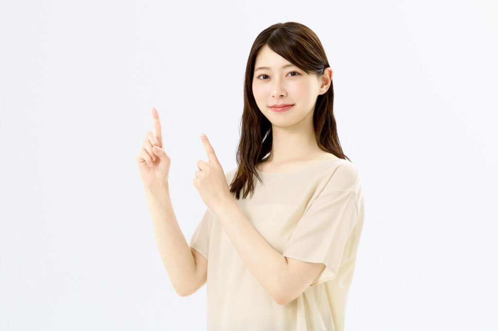 両手で指差しする若い女性の画像