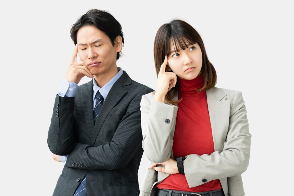 考えごとをする男女2人のビジネスマンの写真