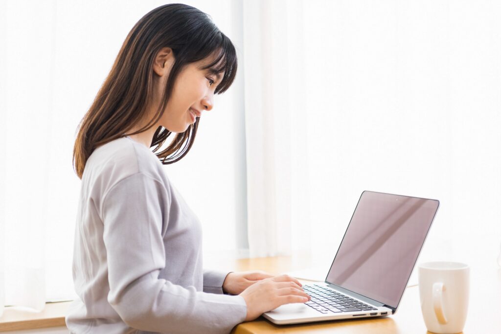 パソコンをする若い女性の画像