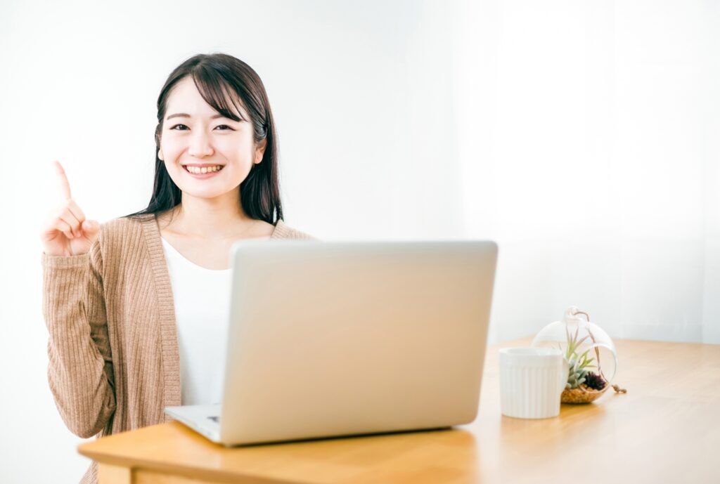 笑顔で指を指している女性の画像